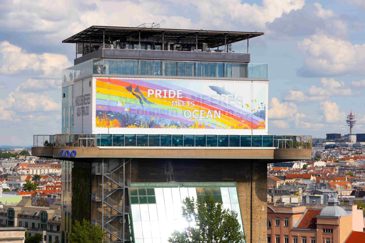 großer Banner mit Regenbogen und Tauchmotiv unter der Terrasse am Turm affichiert